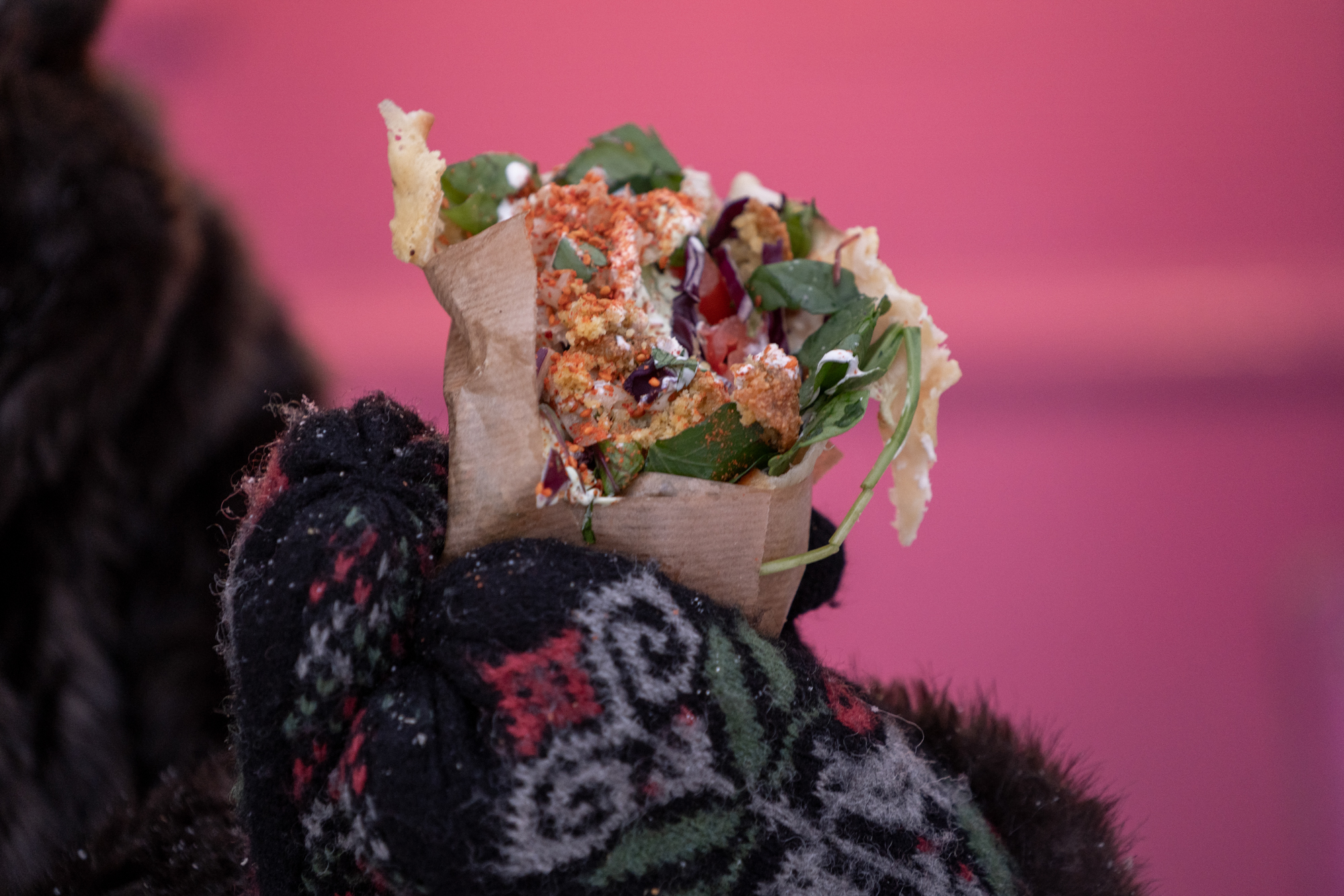 en pink truck quesadilla som hålls i med färgglada vantar