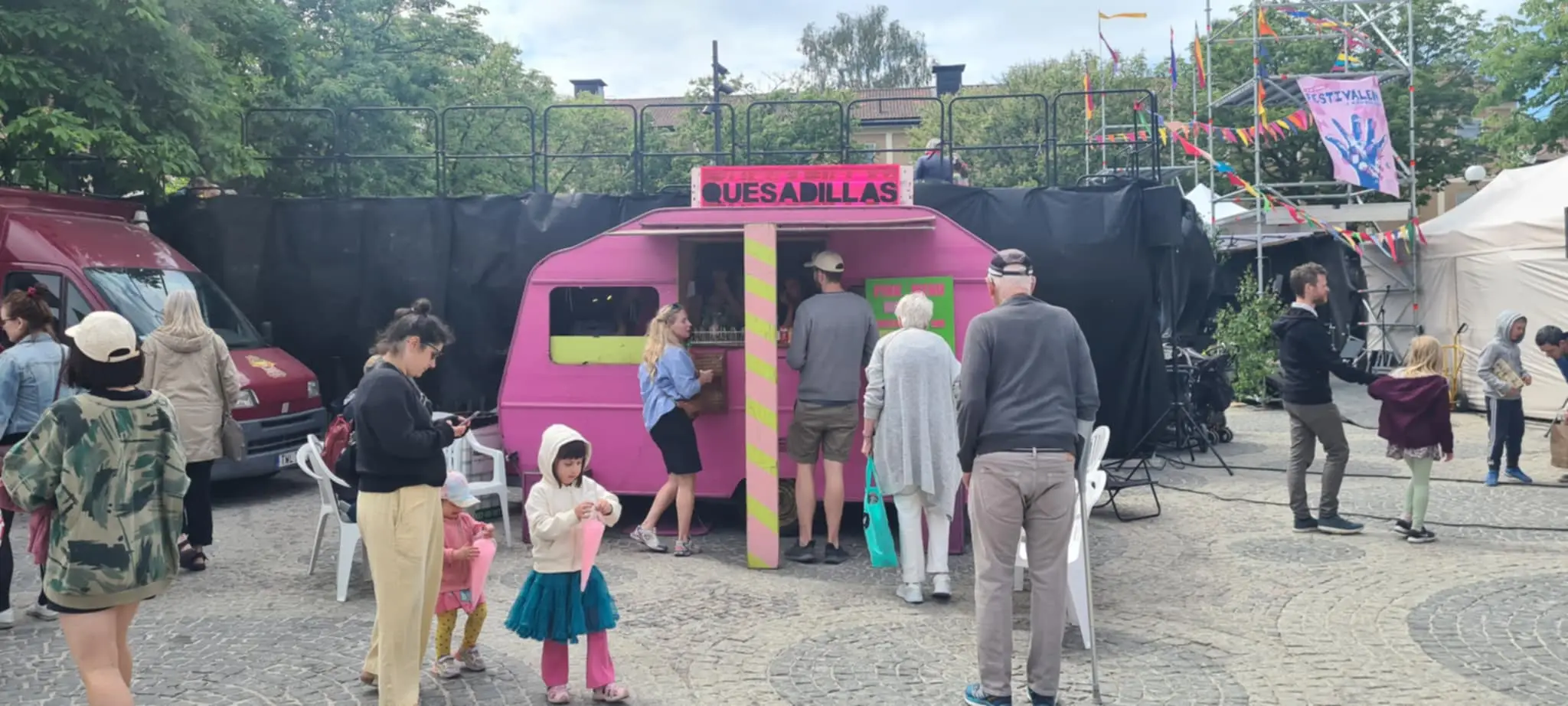 människor och scen och en rosa food truck på en festival i kärrtorp i stockholm